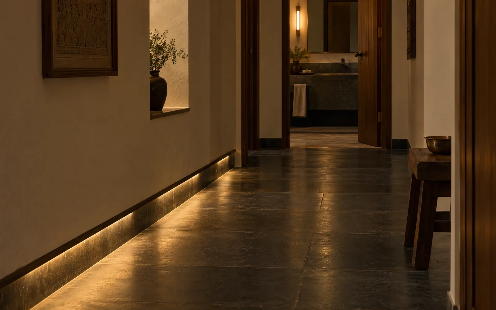 A corridor at night lit by a low path light along the skirting.